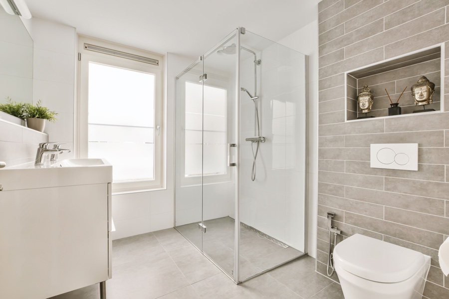 a bathroom with a toilet, sink and shower stall in the corners on the left side of the room